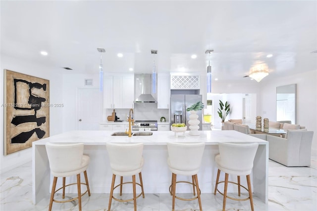 kitchen with white cabinets, stainless steel fridge with ice dispenser, wall chimney exhaust hood, marble finish floor, and recessed lighting