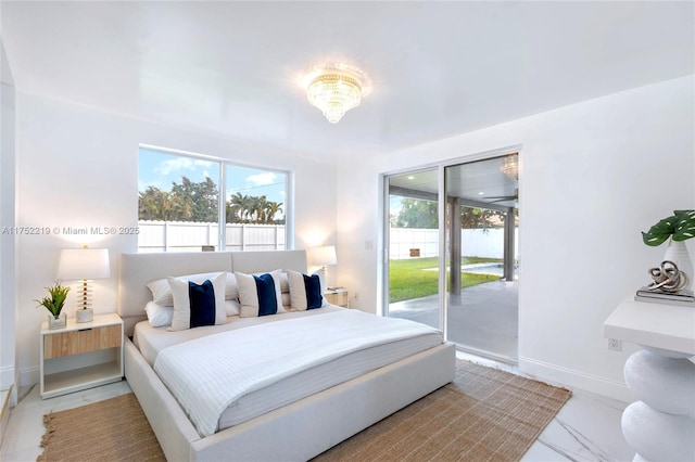 bedroom featuring access to exterior, marble finish floor, and baseboards