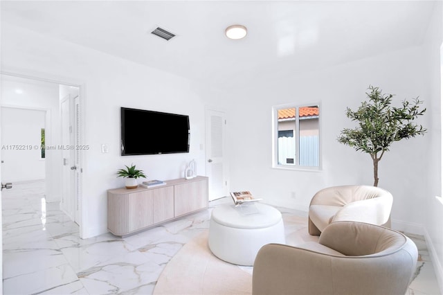 living area with marble finish floor, visible vents, and baseboards