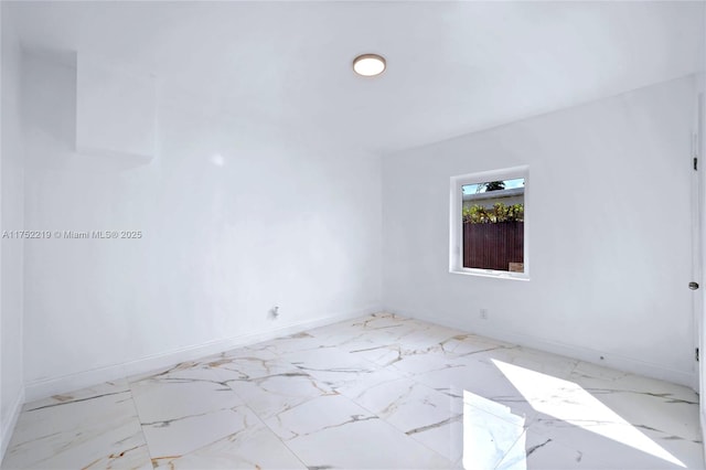 empty room with marble finish floor and baseboards