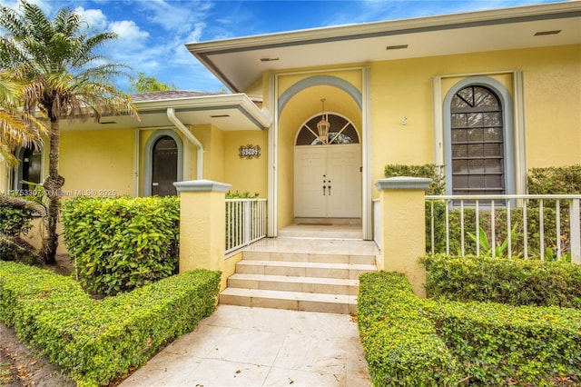 entrance to property featuring stucco siding