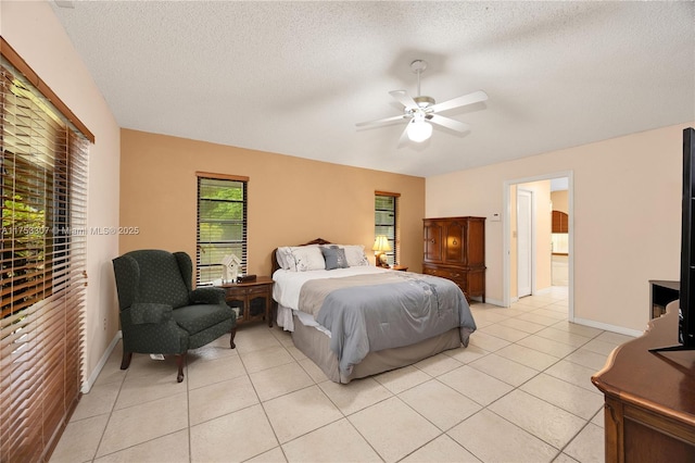 bedroom with light tile patterned floors, ceiling fan, and a textured ceiling