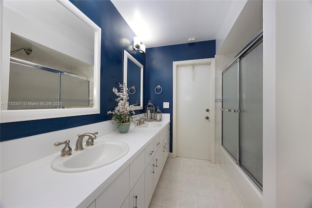 bathroom featuring tile patterned floors, enclosed tub / shower combo, a sink, and double vanity