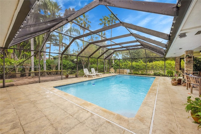 pool featuring glass enclosure and a patio area