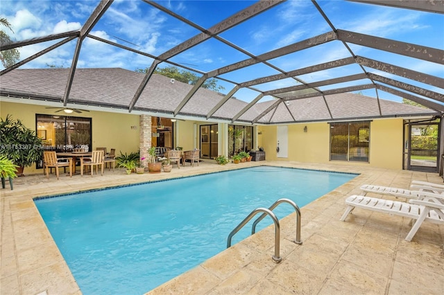 outdoor pool with a lanai, ceiling fan, and a patio