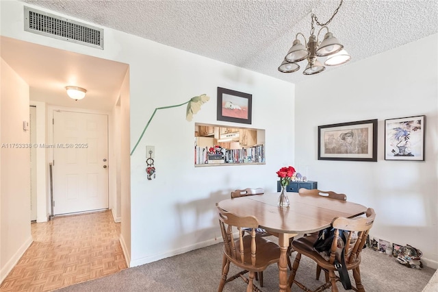 dining space with baseboards, visible vents, and a textured ceiling