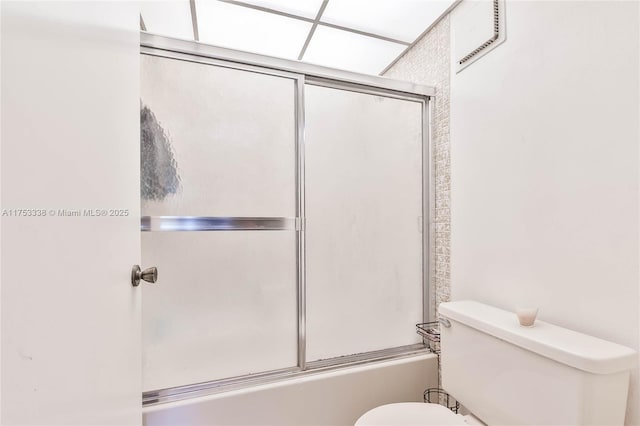 bathroom with combined bath / shower with glass door, visible vents, and toilet