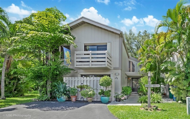 view of front of home with fence and a balcony