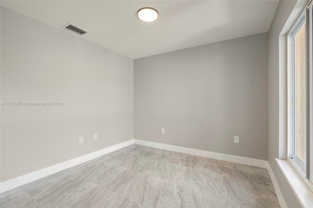 empty room with baseboards and visible vents