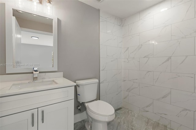 bathroom with toilet, tiled shower, and vanity