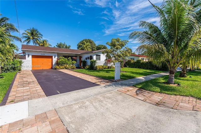 ranch-style house with a front yard, concrete driveway, an attached garage, and stucco siding