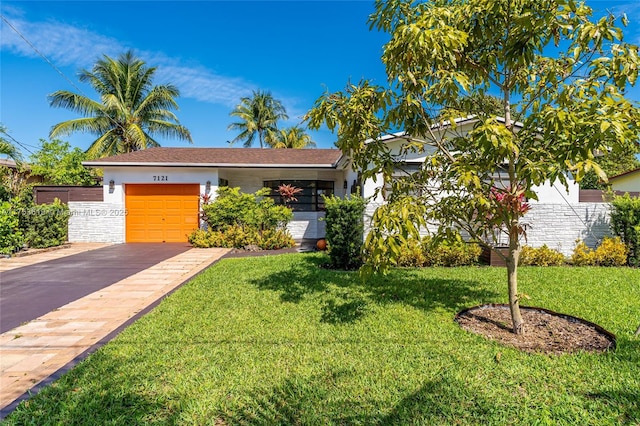 view of front facade with a front lawn, driveway, an attached garage, and stucco siding