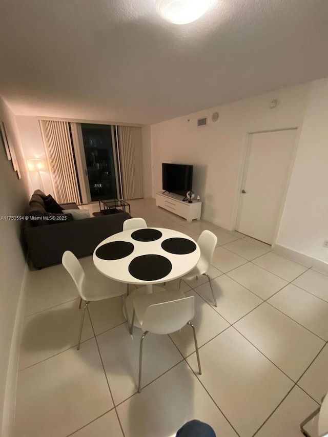 dining area featuring light tile patterned flooring, visible vents, and baseboards