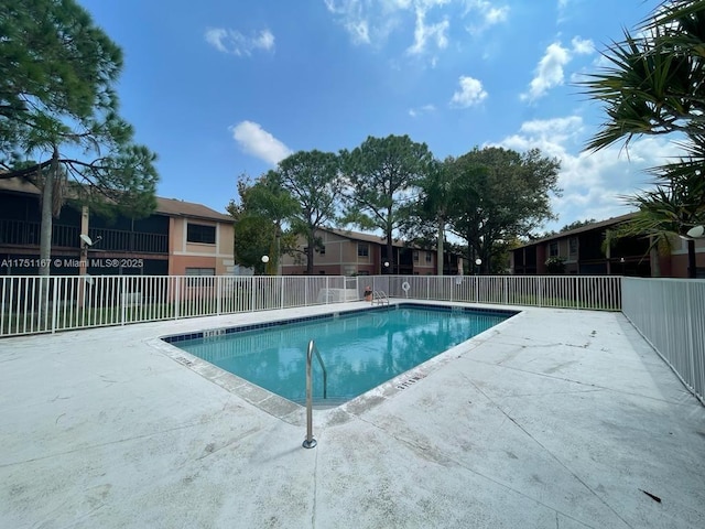 pool with a patio area and fence