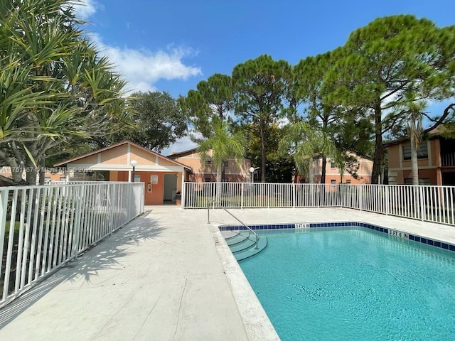 community pool with a patio and fence