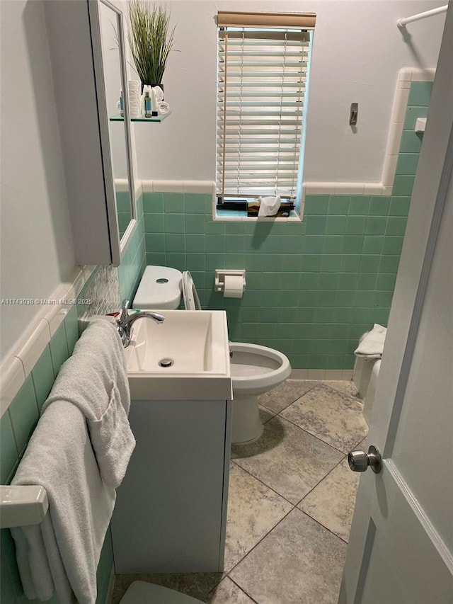 bathroom featuring toilet, wainscoting, vanity, and tile patterned floors