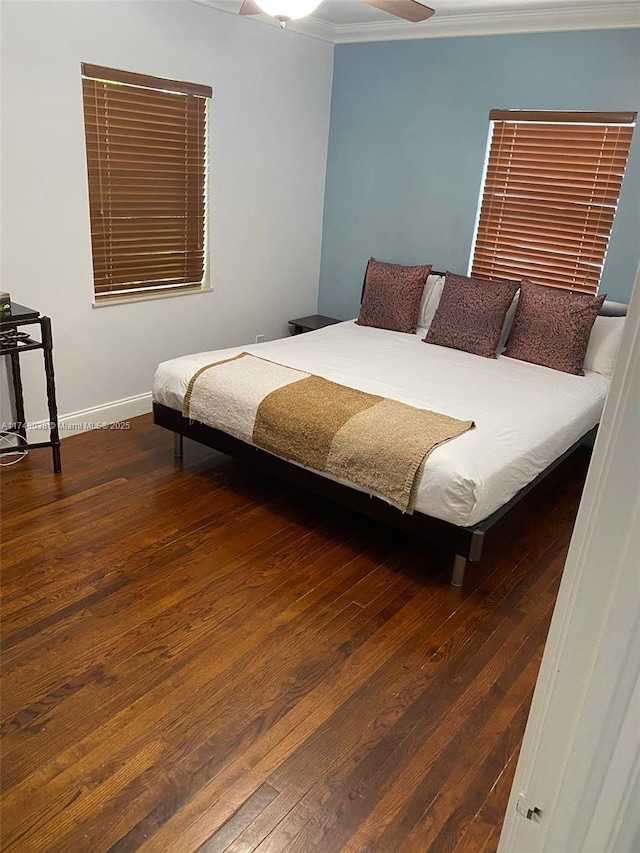 bedroom featuring wood-type flooring, baseboards, ceiling fan, and crown molding