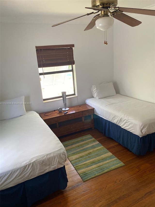 bedroom with ceiling fan, ornamental molding, and wood finished floors