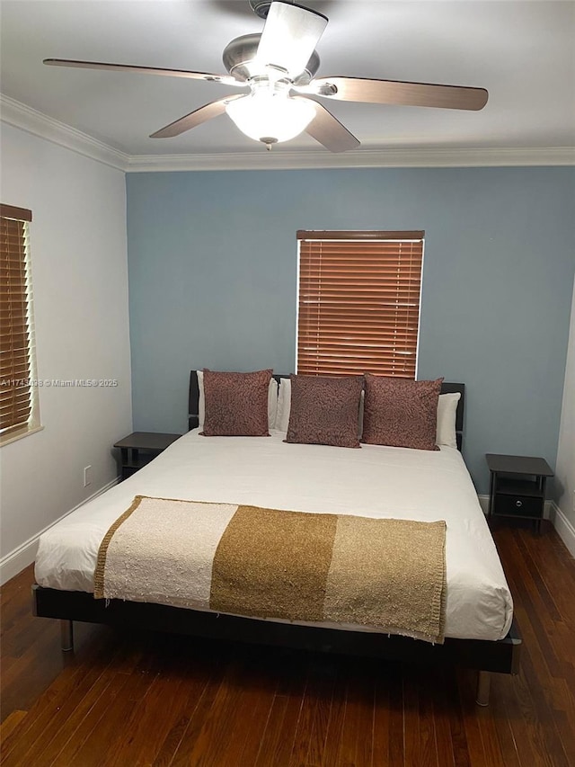 bedroom featuring ornamental molding, wood-type flooring, a ceiling fan, and baseboards