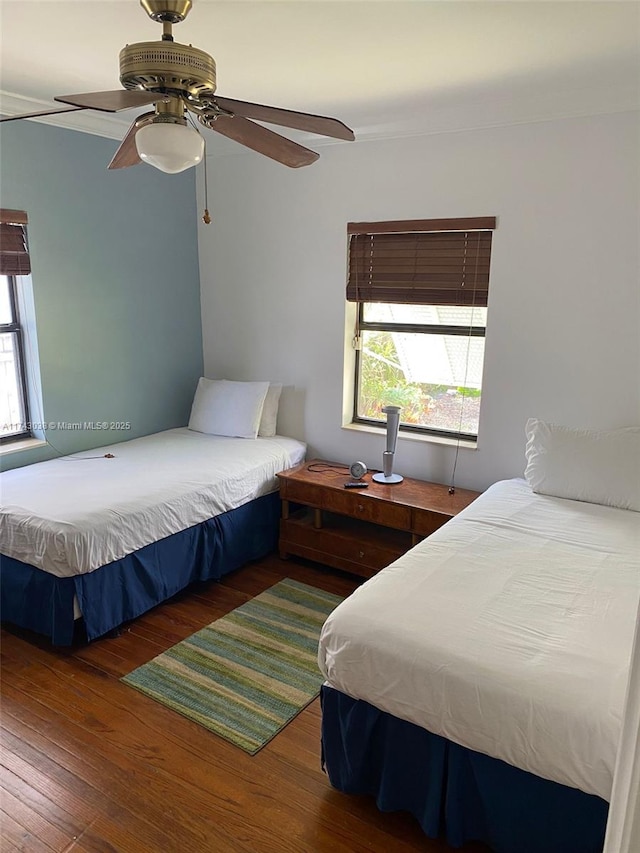 bedroom with a ceiling fan, multiple windows, and hardwood / wood-style floors