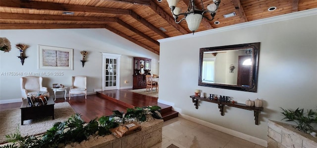 living area with lofted ceiling with beams, wood ceiling, and baseboards