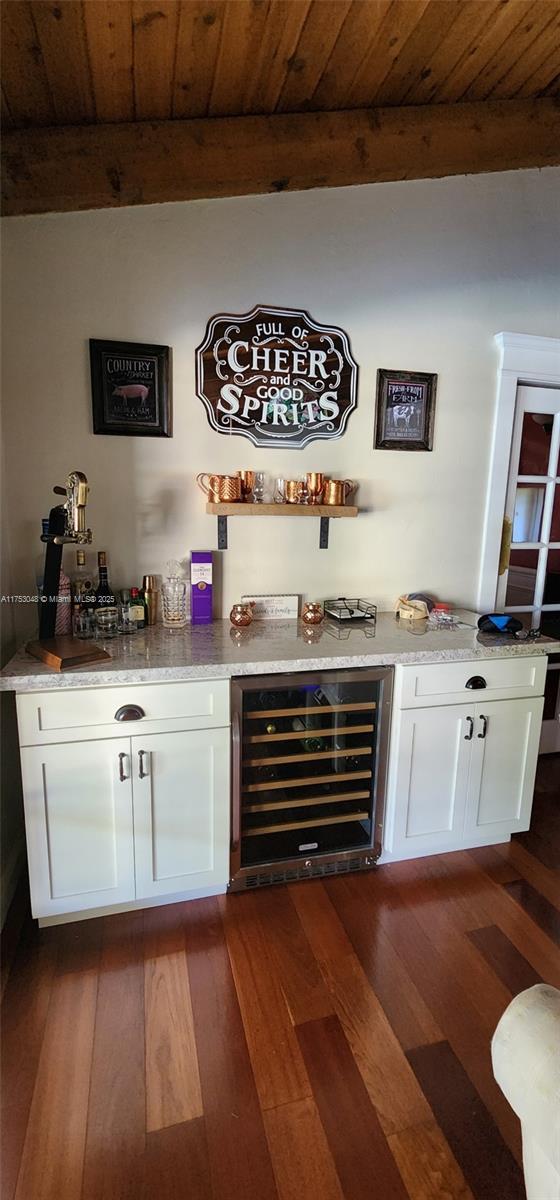 bar with wood ceiling, beverage cooler, beamed ceiling, and a dry bar