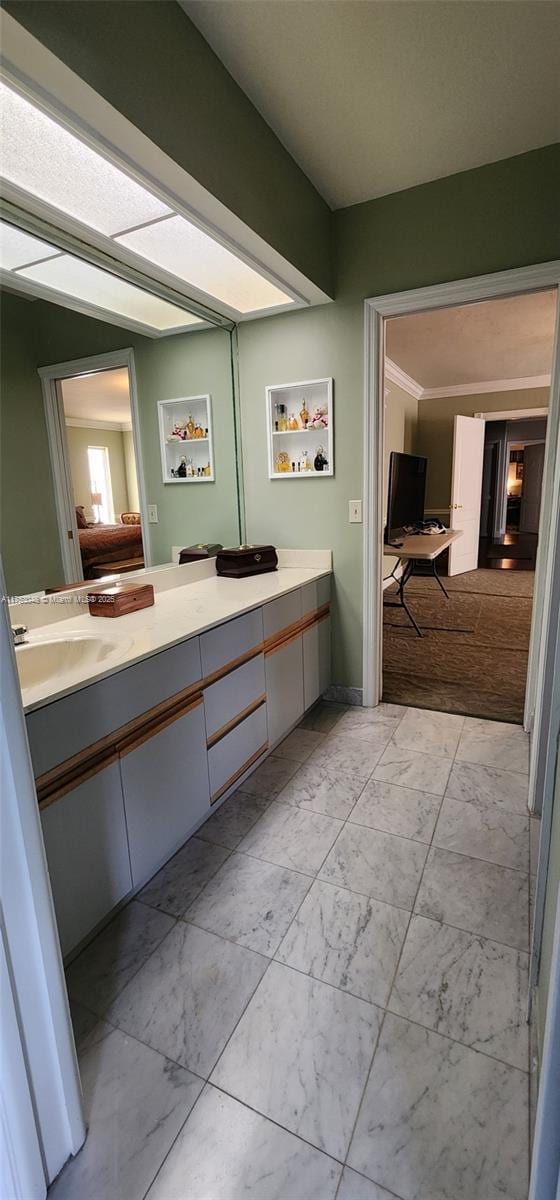 ensuite bathroom featuring marble finish floor, connected bathroom, and vanity