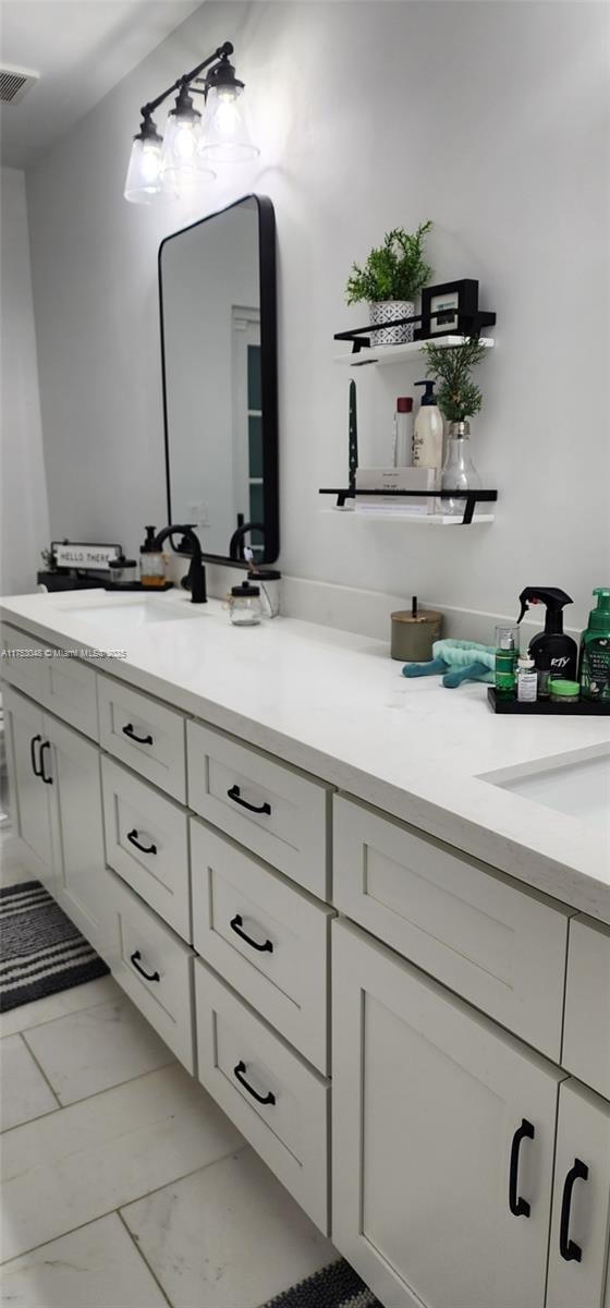 bathroom featuring double vanity, marble finish floor, and visible vents