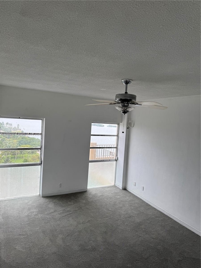 spare room featuring a textured ceiling, a ceiling fan, and carpet flooring