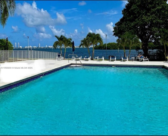 community pool with fence and a patio