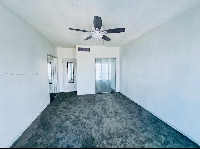 unfurnished bedroom featuring a textured ceiling, carpet, visible vents, and baseboards