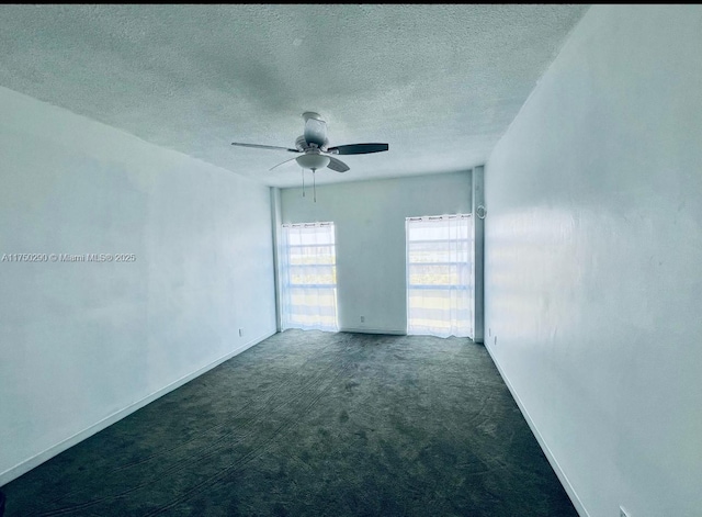 carpeted spare room featuring a textured ceiling, a ceiling fan, and baseboards