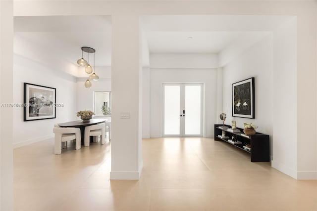 foyer with french doors and baseboards