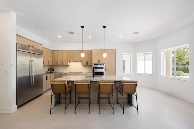 kitchen with visible vents, a center island with sink, appliances with stainless steel finishes, and tasteful backsplash