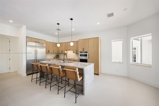 kitchen with recessed lighting, a breakfast bar, visible vents, appliances with stainless steel finishes, and an island with sink