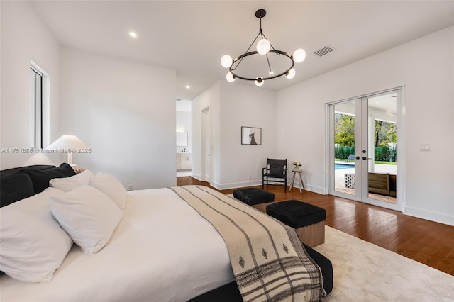 bedroom with baseboards, wood finished floors, visible vents, and access to exterior