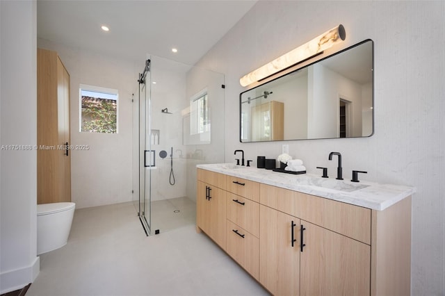 full bath featuring a sink, a shower stall, toilet, and double vanity