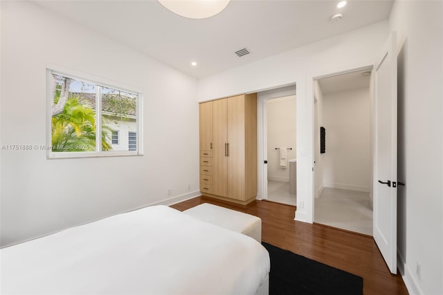 bedroom featuring recessed lighting, visible vents, ensuite bathroom, wood finished floors, and baseboards