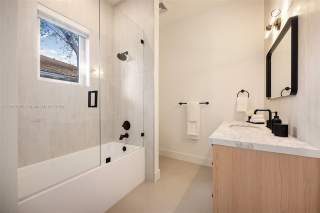 bathroom featuring visible vents, enclosed tub / shower combo, vanity, and baseboards