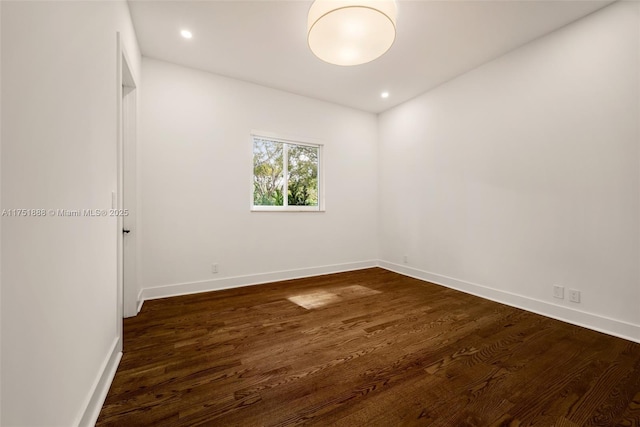 spare room featuring recessed lighting, dark wood finished floors, and baseboards