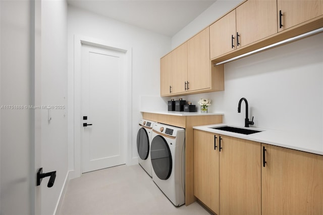 laundry room featuring cabinet space, independent washer and dryer, and a sink