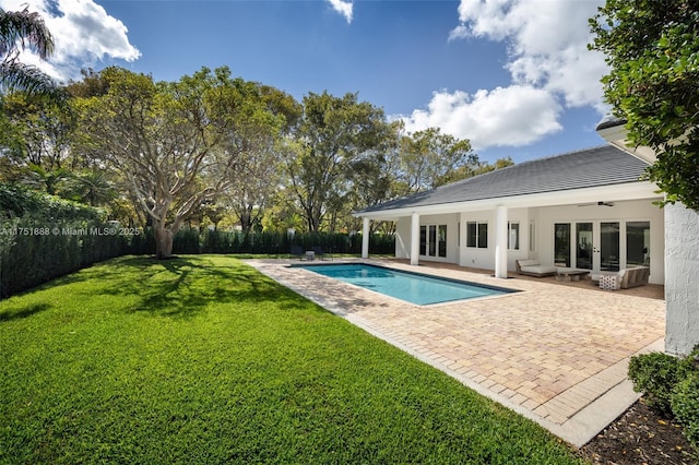 view of swimming pool featuring a patio area, a fenced backyard, a lawn, and french doors