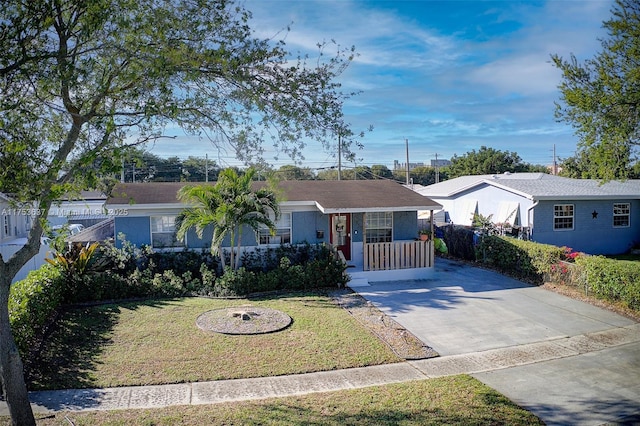 ranch-style house with a porch, concrete driveway, fence, and a front lawn