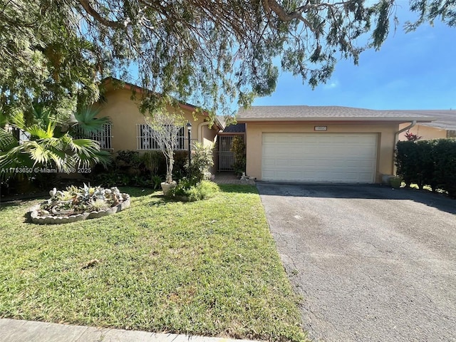 single story home with a garage, driveway, a front lawn, and stucco siding