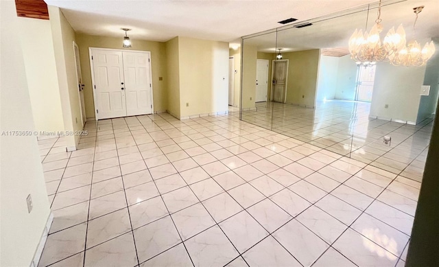 unfurnished room featuring light tile patterned floors, visible vents, and baseboards