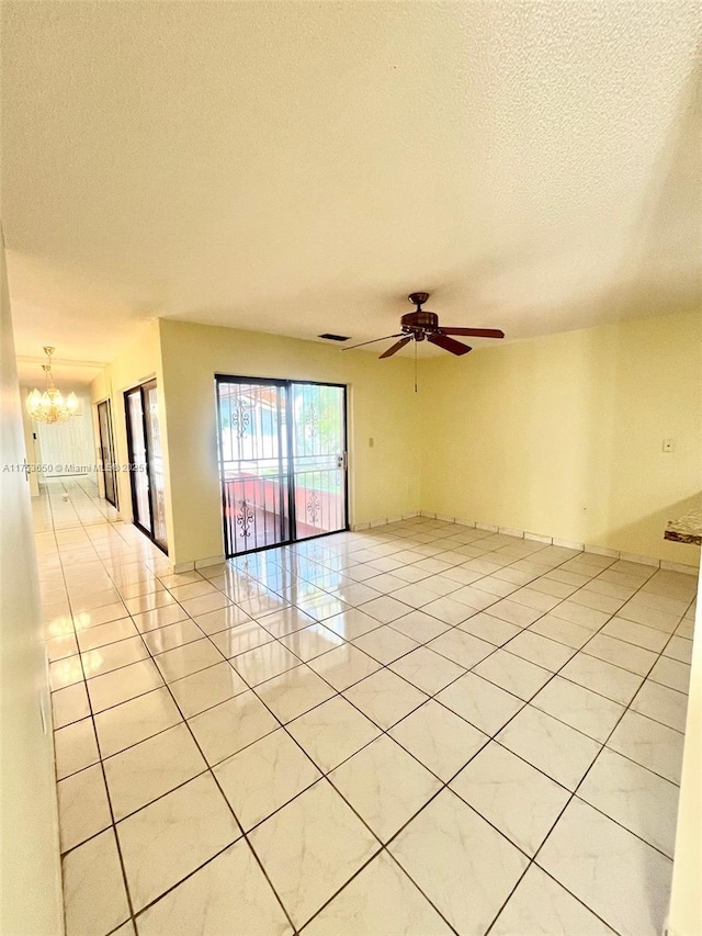 unfurnished room with light tile patterned floors, visible vents, a textured ceiling, and ceiling fan with notable chandelier