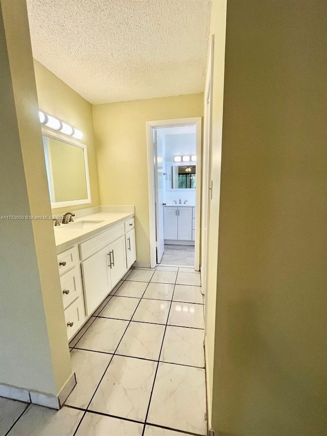 bathroom featuring tile patterned floors, a textured ceiling, and vanity