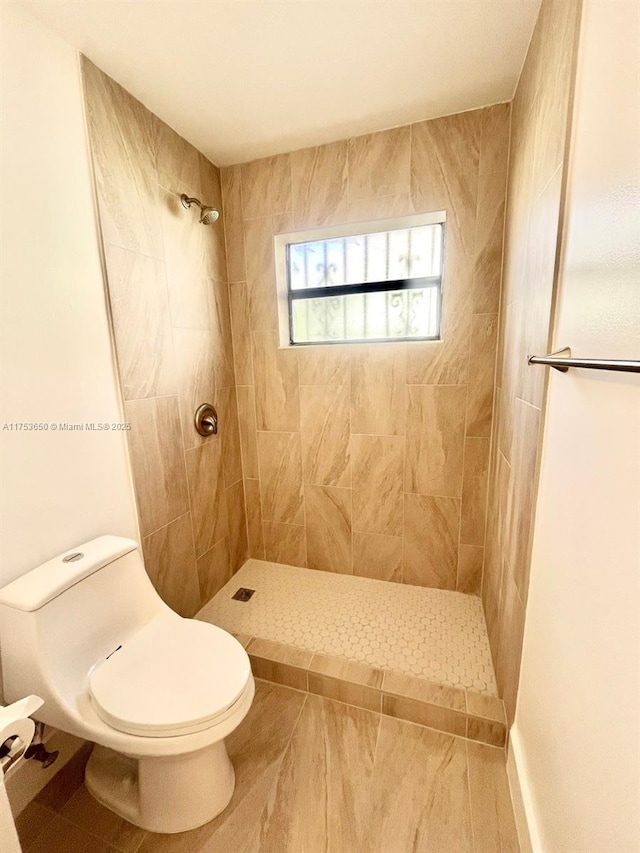 full bath with tiled shower and toilet