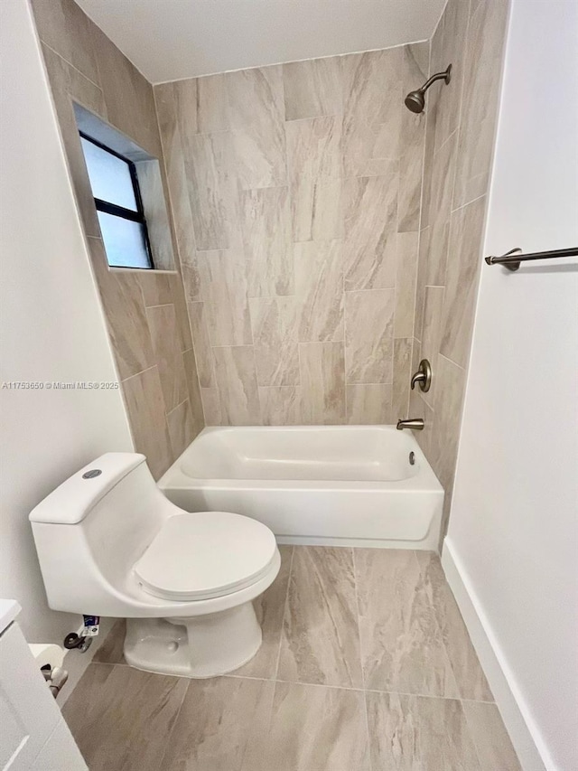 bathroom with toilet, baseboards, and shower / bathtub combination