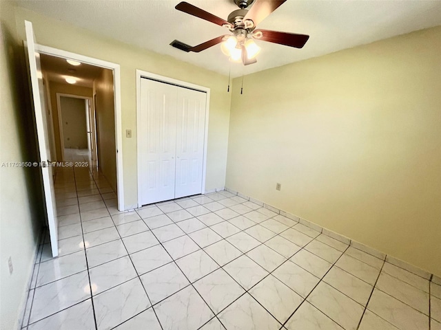 unfurnished bedroom featuring light tile patterned floors, a ceiling fan, and a closet